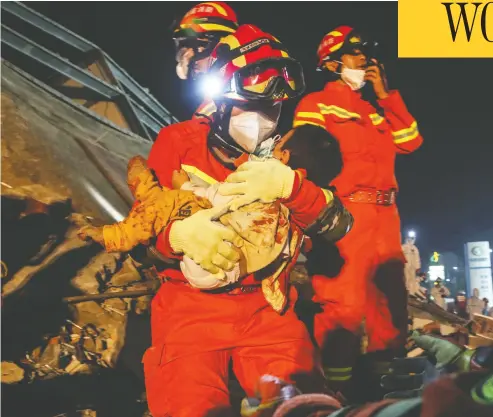  ?? STR / AFP via Gett
y Imag
es ?? A boy is rescued from the rubble of a hotel in Quanzhou, China on Sunday. Ten people have died and 23 remain
trapped after the building, being used as a coronaviru­s quarantine facility, caved in.