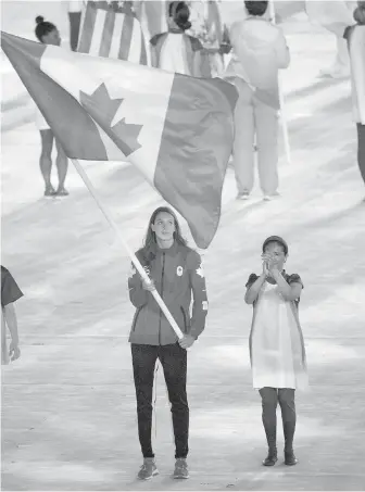  ?? JASON RANSOM, THE CANADIAN PRESS ?? Penny Oleksiak carries the Canadian flag into the closing ceremonies in Rio de Janeiro, Brazil, on Sunday. Oleksiak won four medals in swimming.