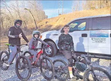  ?? (NWA Democrat-Gazette/Sally Carroll) ?? Josh, (from left) Lexie and Maverick Whittle of Bella Vista take to the trails on a recent Sunday afternoon. The trio loves to ride the trails and enjoys being only 10 minutes to any type of amenity, Josh Whittle said.