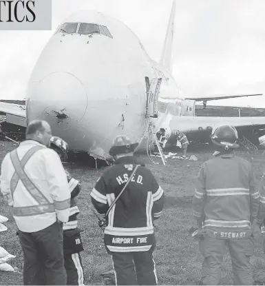  ?? ANDREW VAUGHAN / THE CANADIAN PRESS ?? A Skylease Cargo jumbo jet with five people aboard skidded off a runway at Halifax’s Stanfield Airport, coming to a stop near a road early Wednesday. The airport suspended all flights after the incident.