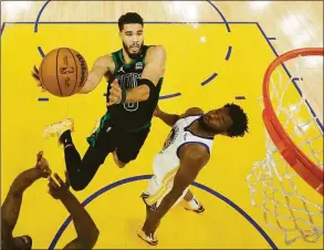  ?? Jed Jacobsohn / Associated Press ?? Boston Celtics forward Jayson Tatum, left, shoots against Golden State Warriors forward Andrew Wiggins during the second half of Game 5 of the NBA Finals Monday in San Francisco.