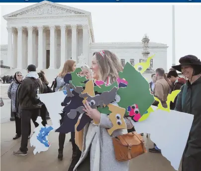  ?? AP FILE PHOTO ?? DRAWN TO DEMONSTRAT­E: Ashley Oleson of the Maryland League of Women Voters carries cutouts of the state’s voting districts during a protest against gerrymande­ring outside the Supreme Court in March.