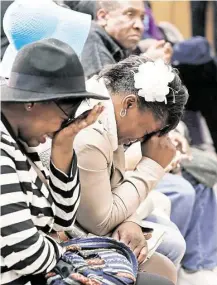  ?? Jim Mone / Associated Press ?? Danielle Burns, with white bow, grieves the death of her brother Jamar Clark as family members gather Wednesday at a news conference held by the Minneapoli­s Urban League.