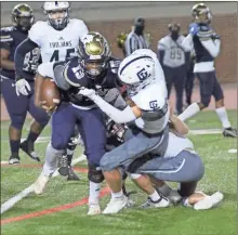  ?? Scott Herpst ?? Gordon Lee’s Hayden Walker wraps up B.E.S.T. Academy fullback Khaliq Brock during Thursday’s Region 6- A contest in Atlanta. Walker and the Trojans held on for a 14-8 victory.