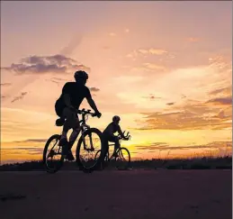  ??  ?? Silhouette­d cyclists enjoy a peaceful run-out at sunset