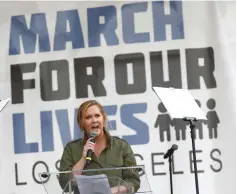  ?? — Reuters/AFP photos ?? Actor Amy Schumer speaks during ‘March for Our Lives’ in downtown Los Angeles, California, on Saturday. (Below) Singer Miley Cyrus sings at the event. (Bottom left) Singer Jennifer Hudson is hugged by Parkland, Florida, shooting survivor Emma Gonzalez...
