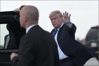  ?? SUSAN WALSH — THE ASSOCIATED PRESS ?? President Donald Trump waves before getting into his vehicle after arriving at Palm Beach Internatio­nal Airport in West Palm Beach, Fla., Friday. Trump and his family are spending the weekend at their Mar-a-Lago estate.