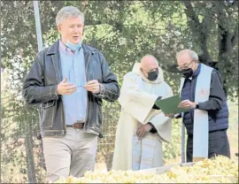  ?? PHOTO BY OLENA KOVTAS ?? Rob Jensen, left, co-owner of Testarossa, speaks at the winery’s blessing of the grapes earlier this month while priests Tony Mancuso, center, and Peter Pabst check their notes.