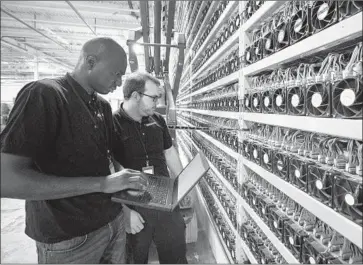  ?? Lars Hagberg AFP via Getty Images ?? TECHNICIAN­S monitor bitcoin mining at Bitfarms in Quebec in 2018. Bitcoin is down about 17% this month.
