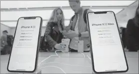  ??  ?? Dos personas miran el nuevo iPhone XS Max en exhibición en una sucursal de Apple en Nueva York
