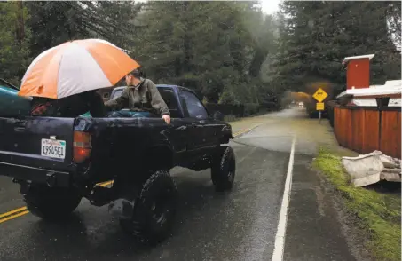  ?? Leah Millis / The Chronicle ?? Residents prepare to take a loaded pickup across a flooded road in Guernevill­e, where a 38.4-foot crest is expected Wednesday.