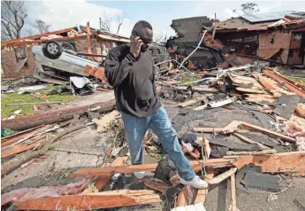  ?? GERALD HERBERT, AP ?? Anthony Brown walks through the debris of his neighbor’s house Wednesday, a day after a tornado ripped through New Orleans as severe storms swept through the South this week.