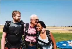  ??  ?? Jason Ashcroft, left, Wendell Ashcroft, and Danielle Garrick share a family hug after landing safely from their first skydiving experience at Skydive Ogden. — AP photos