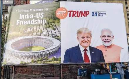  ?? AFP ?? An elderly man sits below a billboard depicting US President Donald Trump with India’s Prime Minister Narendra Modi.