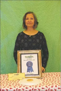  ?? Courtesy photo ?? Doris Vasquez stands with one of her winning entries in the ninth annual biscochito contest Dec. 13 at Taos Herb Co.