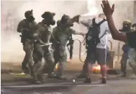  ?? THE PORTLAND TRIBUNE / VIA REUTERS ?? A man is sprayed by a police officer during a protest against racial inequality in Portland, Ore., last month.