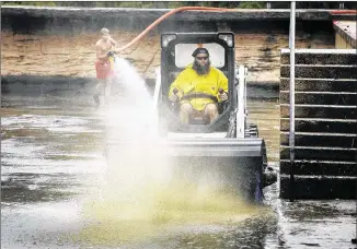  ?? RALPH BARRERA/ AMERICAN-STATESMAN ?? Crews were on hand early Sunday to begin the regular after-storm cleanup of Barton Springs Pool in Zilker Park. Manager Connor Hopkins drives a Bobcat with a heavy-duty scrub brush, while lifeguards handle a high-pressure hose to assist in breaking up...