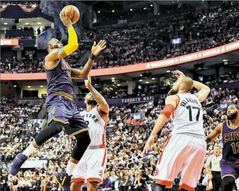  ?? Frank Gunn/Associated Press ?? LeBron James shoots as Toronto forward P.J. Tucker, from left, center Jonas Valanciuna­s and Cavaliers center Tristan Thompson look on in the second half of the Cavaliers’ win, sending them to the Eastern Conference Finals.