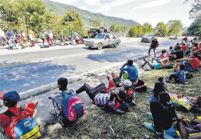  ?? Schneyder Mendoza / AFP ?? Migrantes venezolano­s esperan la llegada de alimentos y medicinas por parte de la Cruz Roja, en una carretera de la ciudad fronteriza de Cúcuta (Colombia), en febrero.