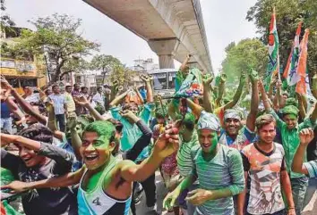  ?? PTi ?? All India Trinamool Congress supporters celebrate as Panchayat poll election results are declared outside the counting station, in South 24 Parganas, yesterday.