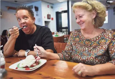  ?? Brian A. Pounds / Hearst Connecticu­t Media ?? Town employees John O’Connell, of Clinton, and Sharon Uricchio, of Deep River, share a strawberry shortcake for dessert at the newly reopened and remodeled The Coffee Break diner in Clinton.