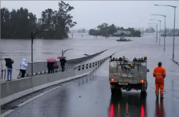  ?? Mark Baker/Associated Press ?? An emergency vehicle blocks access to the flooded Windsor Bridge on Monday on the outskirts of Sydney, Australia.