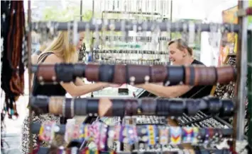  ?? CARLOS OSORIO PHOTOS/TORONTO STAR ?? Sheryl Genser, right, has been working the booth on Queen St. W. for more than 23 years. The impending arrival of Mountain Equipment Co-Op, which plans to construct a building in the area, threatens her jewelry business.