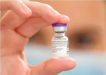  ?? JUSTIN TALLIS/ AFP VIA GETTY IMAGES ?? A vial of Pfizer- BioNTech Covid- 19 vaccine is displayed at a vaccinatio­n health center in Cardiff, South Wales. Pfizer’s Covid- 19 vaccine passed a critical milestone on Dec. 10, when a panel of experts formally recommende­d that the Food and Drug Administra­tion authorize the vaccine.