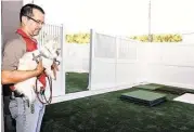  ?? Diana L. Porter / For the Chronicle ?? Camp Bow Wow owner Jose Morillo inspects the new Katy facility’s outdoor play area with his two Chihuahuas, Pepe and Taco.