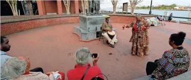  ?? RICHARD BURKHART/SAVANNAH MORNING NEWS ?? An intimate group gathered at the African-American monument on River Street as storytelle­r Lillian Grant-Baptiste performed the opening libation ceremony for the 35th annual Savannah Black Heritage Festival on Feb. 3 on River Street.