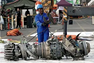  ?? AP ?? Officials move an engine recovered from the crashed Lion Air jet for further investigat­ion in Jakarta. —