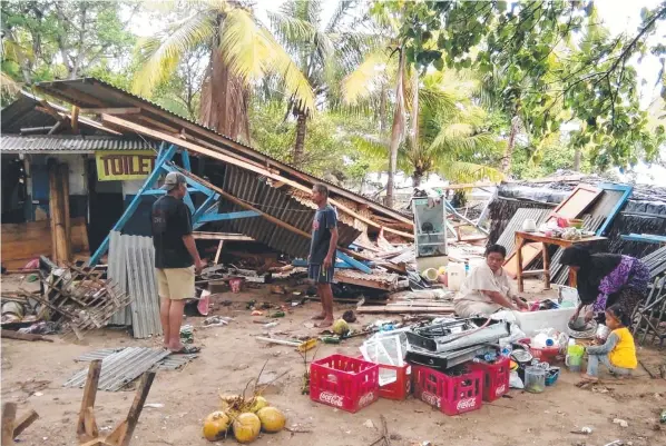  ?? Picture: SEMI/AFP ?? AFTERMATH: People gather salvageabl­e items from damaged buildings on Carita beach yesterday, after the area was hit by a tsunami reported to have been caused by the Anak Krakatoa volcano.