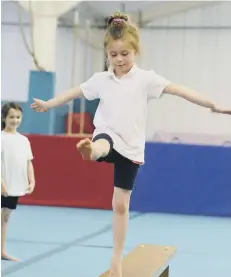  ??  ?? A gymnast shows her balancing ability
152108g