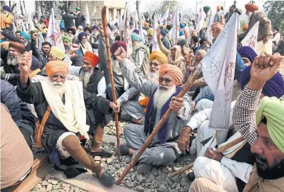  ?? NARINDER NANU AFP VIA GETTY IMAGES ?? Farmers block railway tracks outside Amritsar, India, as part of their protest against agricultur­al reforms they say will favour large corporate farms. The government insists the new laws will benefit all farmers, but has offered to suspend them for 18 months.