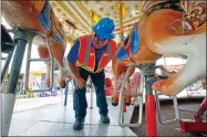  ?? AP PHOTO BY ROGELIO V. SOLIS ?? In this Tuesday, Oct. 6, 2015 file photo, amusement device inspector Avery Wheelock inspects the safety pins on a children’s merry-go-round at the Mississipp­i State Fair in Jackson, Miss.