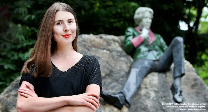  ??  ?? LITERARY ICON: Sophie Donaldson at the Oscar Wilde statue in Merrion Square. Photo: Steve Humphreys