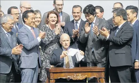  ?? Eric Risberg Associated Press ?? GOV. JERRY BROWN holds up bills in September 2017 addressing the state’s housing needs. Last week, he signed one that “confirmed” that his use of the state’s share of a 2012 settlement with the five major mortgage servicers was consistent with the Legislatur­e’s direction.