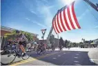  ?? MITSU YASUKAWA/NORTHJERSE­Y.COM VIA USA TODAY NETWORK ?? Bikers ride underneath a huge American flag during a parade in Ridgewood, N.J., on July 4.