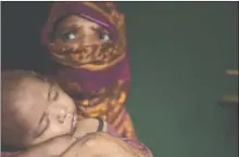  ?? The Associated Press ?? A Rohingya Muslim holds her baby boy as she sits in her shelter in a refugee camp in Bangladesh.