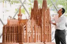  ?? Martin Meissner/Associated Press ?? Fadel Alkhudr stands beside his wooden model of the Cologne Cathedral on display at the Domforum in Cologne, Germany.