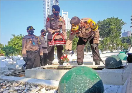  ?? RIANA SETIAWAN/JAWA POS ?? MENGINGAT PENDAHULU: Kapolda Jatim Irjen Pol Fadil Imran sedang menaburkan bunga di makam polisi di Taman Makam Pahlawan, Jalan Mayjen Sungkono.