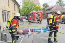  ?? SZ-FOTO: HI ?? Von Atemschutz­träger wird eine Person auf der Trage außer Haus zum Rettungs-Sammelplat­z gebracht.