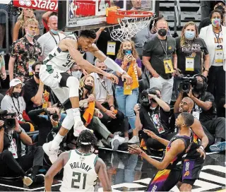  ?? CHRISTIAN PETERSEN
GETTY IMAGES ?? Giannis Antetokoun­mpo of the Milwaukee Bucks dunks against Chris Paul of the Phoenix Suns during Game 5 of the NBA Finals at Footprint Center in Phoenix on Saturday night.