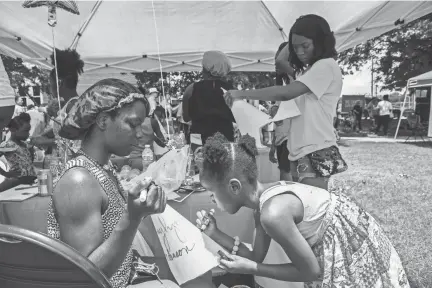  ?? APPEAL ?? Ebony Howell, 19, watches her niece, Zaylynn Anderson, 6, design a hat during the Wear Orange Block Party at Howze Park on Saturday. The event, hosted by the Memphis chapter of Moms Demand Action for Gun Sense in America, had activities for kids and...