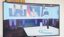  ?? BENOIT TESSIER/REUTERS ?? French President Emmanuel Macron, right on screen, attends a videoconfe­rence meeting Friday with President Joe Biden and German Chancellor Angela Merkel, center, ahead of the Munich Security Conference at the Elysee Palace in Paris.