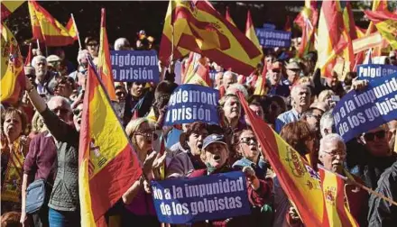  ?? AFP PIC ?? People holding signs reading ‘No to the impunity of coup plotters’ and ‘(Catalan regional president Carles) Puigdemont to prison’ while waving Spanish flags during a pro-unity demonstrat­ion in Madrid yesterday.