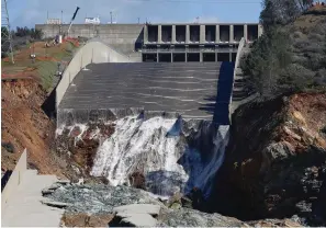  ?? The Associated Press ?? Water flows down the Oroville Dam’s crippled spillway on Feb. 28, 2017, in Oroville, Calif. Americans wondering whether a nearby dam could be dangerous can look up the condition and hazard ratings of tens of thousands of dams nationwide using an online database run by the federal government. But they won’t find the condition of Oroville Dam, which underwent a $1 billion makeover after its spillway failed.