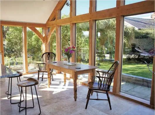  ?? ?? SPACIOUS: Light and space are the defining features of the timber-framed glazed extension, which gives fine views of the garden, at Mowbray House.