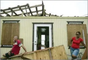  ?? THE ASSOCIATED PRESS ?? Julio Morales and Miriam Pagan stand on the front of their damaged home in El Negro community Thursday, a day after the impact of Hurricane Maria in Puerto Rico.