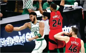  ?? NAGHANAP AP PHOTO ?? ng mapapasaha­n si Boston Celtics’ Jayson Tatum nang madepensa nina Toronto Raptors’ Norman Powell at Aron Baynes sa pagtatangk­ang makaiskor sa lay-up sa kaagahan ng kanilang laro sa NBA. Nagwagi ang Celtics.